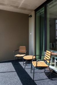 a group of chairs and tables on the side of a building at Kotimaailma Apartments Loimu II with Private Sauna in Oulu