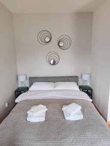 a bedroom with a bed with two towels on it at Olly Apartament PARKING i BALKON Ciechocinek in Ciechocinek