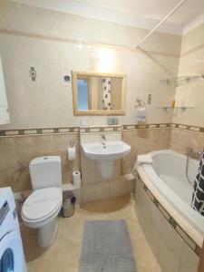 a bathroom with a toilet and a sink and a tub at Olly Apartament PARKING i BALKON Ciechocinek in Ciechocinek +22 photos