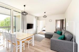a living room with a table and a couch at Kotimaailma Apartments Loimu II with Private Sauna in Oulu