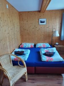 a bedroom with a blue bed and a chair at Penzion Sportka 