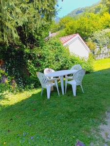a picnic table and two chairs in the grass at Chambre à louer 15mnn de Grenoble-salle de bain privée-WIFI gratuit in Fontanil-Cornillon