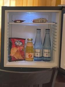 a refrigerator with three bottles of soda and snacks at Hotel City Inn Hamburg-Mitte in Hamburg