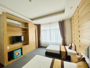 Cette chambre comprend 2 lits et une télévision à écran plat. dans l'établissement DREAM HOTEL Bắc Ninh, à Hòa Ðình