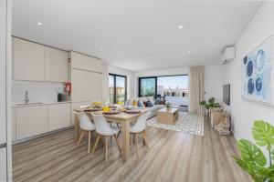 cocina y sala de estar con mesa y sillas en Terraços de Quarteira Zen by Real Properties, en Quarteira
