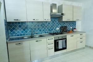 a kitchen with white cabinets and a sink and a stove at Belvedere in Tagliacozzo