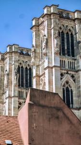 un grand bâtiment avec une grande tour et une horloge dans l'établissement Le Sommelier Chalon, à Chalon-sur-Saône