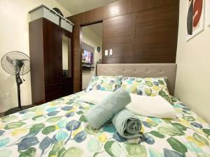 1 dormitorio con 1 cama con colcha de flores y ventilador en Air Residences with Fast Wifi, en Manila
