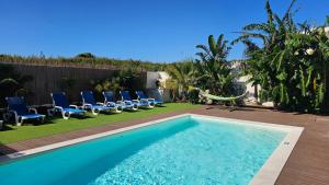 una piscina con sillas y una hamaca en un patio en Seabreeze- Vista Mar-Vivenda Privada-Near Ericeira, en São Pedro da Cadeira