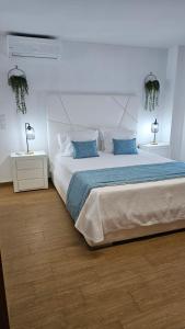 a bedroom with a large bed with blue pillows at Seabreeze- Vista Mar-Vivenda Privada-Near Ericeira in São Pedro da Cadeira