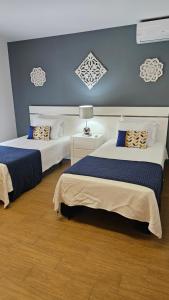 a bedroom with two beds and a blue wall at Seabreeze- Vista Mar-Vivenda Privada-Near Ericeira in São Pedro da Cadeira