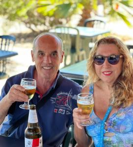 Ein Mann und eine Frau mit Biergläsern in der Unterkunft B&B Marino E Lily in Baratili San Pietro