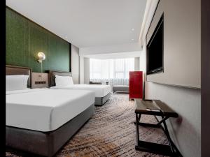 Voodi või voodid majutusasutuse Shenzhen Shanghai Hotel toas
