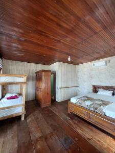a bedroom with two beds and a wooden ceiling at Angso Duo Resort in Pariaman