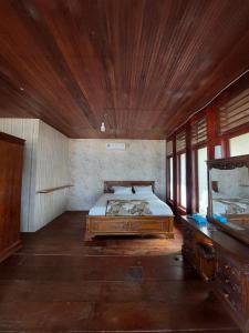 a bedroom with a bed and a wooden ceiling at Angso Duo Resort in Pariaman