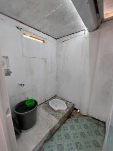 a bathroom with a toilet and a bucket in it at Angso Duo Resort in Pariaman