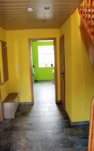 a hallway of a house with yellow walls and a staircase at Ferienwohnung Nagel 