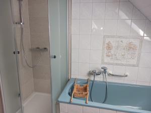 a bathroom with a shower and a basket on a tub at Ferienwohnung Nagel 