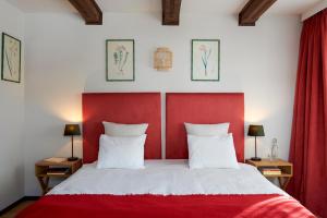 a bedroom with a red headboard and a white bed at Maison d'hôtes Ermitage in Chateau-d'Oex