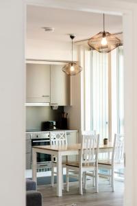 a kitchen with a dining room table and chairs at Kotimaailma Apartments Loimu I in Oulu