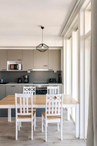 a kitchen with a wooden table and chairs at Kotimaailma Apartments Loimu I in Oulu