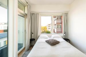a bedroom with a bed and a large window at Kotimaailma Apartments Loimu I with Private Sauna in Oulu