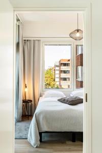 a bedroom with a bed and a large window at Kotimaailma Apartments Loimu I in Oulu