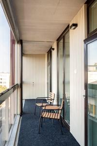 a balcony with two chairs and a table on a building at Kotimaailma Apartments Loimu I with Private Sauna in Oulu