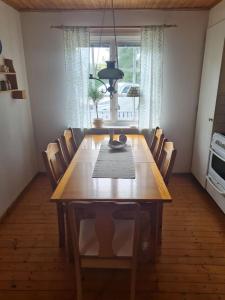 a dining room table with chairs and a chandelier at Trevlig och havsnära stuga in Glommen