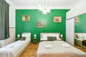 two beds in a room with a green wall at Stunning Charles Bridge Apartment in Prague