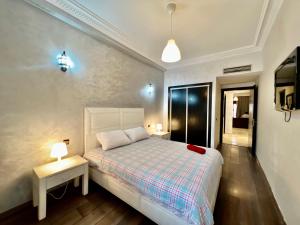 マラケシュにあるSabor Apartment Anas Majorelleのベッドルーム1室(ベッド1台、ランプ2つ付きのテーブル付)