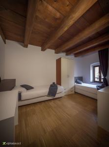 a large room with two beds and a wooden ceiling at B&B Gli Scorci di Trento in Trento