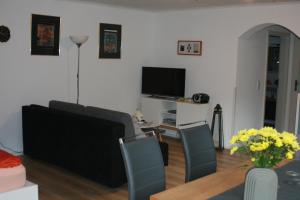 ザンクト・アルデグントにあるFerienwohnung Jattaのリビングルーム(ソファ、椅子、テレビ付)