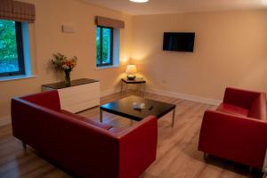uma sala de estar com duas cadeiras vermelhas e uma mesa de centro em Castle Dargan Hotel em Sligo