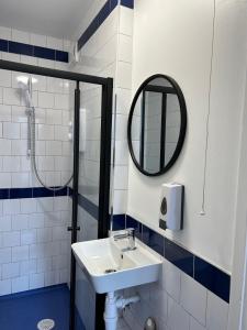 een badkamer met een wastafel en een spiegel bij Cricketers Hostel in Londen