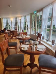 a dining room with tables and chairs and windows at Leixlip Manor Hotel in Leixlip