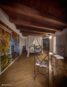 トレントにあるB&B Gli Scorci di Trentoのベッドルーム1室(ベッド1台付)が備わります。壁には絵画が飾られています。