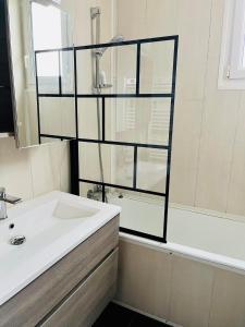 a bathroom with a sink and a tub and a mirror at Le Clos Cornely-maison rénovée Carnac-14 couchages in Carnac