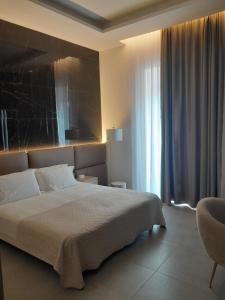 um quarto com uma cama grande e uma janela em BAARIA House Hotel em Barcellona Pozzo di Gotto