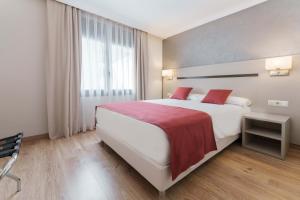 Rúm í herbergi á Hotel & Aparthotel Cosmos