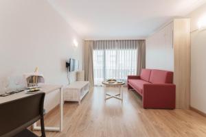 a living room with a red couch and a table at Hotel & Aparthotel Cosmos in Andorra la Vella