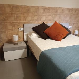 メリダにあるApartamentos Turísticos Domus Aquaeのベッドルーム1室(ベッド2台、ナイトスタンドのランプ付)