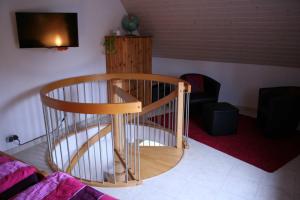 a wooden spiral staircase in a living room at Ferienhaus Auszeit in Waldsolms