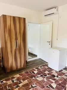 a kitchen with a wooden cabinet and a refrigerator at Azra River View House in Bihać +3 photos