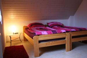 a bedroom with a wooden bed with pink sheets at Ferienhaus Auszeit in Waldsolms