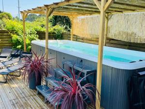 a swimming pool with a pergola and two plants at Le Clos Cornely-maison rénovée Carnac-14 couchages in Carnac