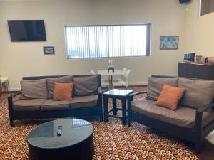 a living room with two couches and a table at Inspirations Mullewa in Mullewa