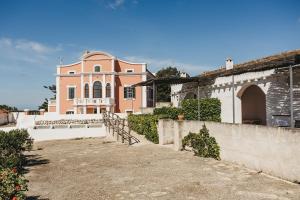 una gran casa rosa y blanca con una valla en Agroturismo Son Triay, en Ferreries