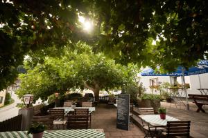 eine Terrasse mit Tischen, Stühlen und einem Baum in der Unterkunft Breitenfelderhof zur Riegersburg in Breitenfeld an der Rittschein