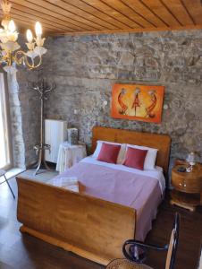 um quarto com uma cama grande numa parede de pedra em Chora Samothrakis, House with courtyard em Samotrácia